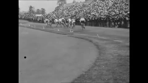 MANCHESTER - 1901 - Cyclists move past small Union Jack flags planted by the Stock Footage 341990579