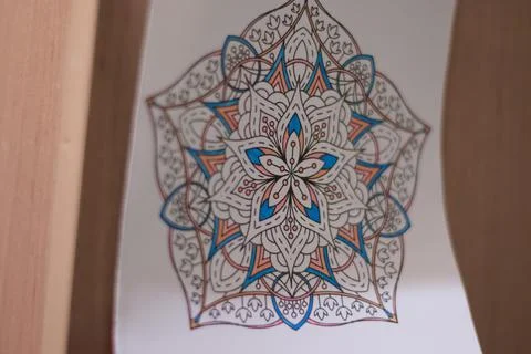 Mandala pattern art illustration on white paper hanging on wooden wall Stock Photos