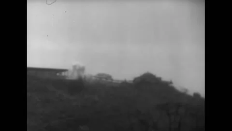 MANDALAY - 1945 - Multiple bombs explode on a Japanese-held hilltop. Smoke rises Stock Footage 312792775