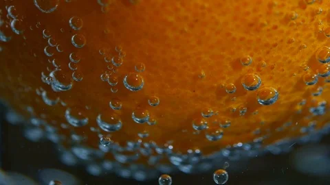 Mandarin falls into water on black background. Slow motion macro shot Stock Footage 100401809