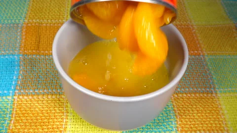 Mandarin orange segments with juice being poured into a bowl. Stock Footage 200873333