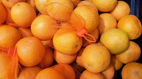 Mandarin oranges put in a mesh bag to be sold in the market. Stock Photos