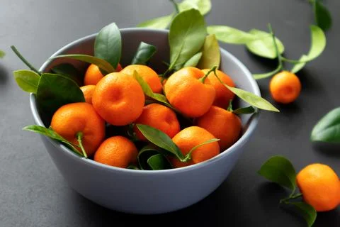 Mandarins or clementines with leaves on a black background. Tangerines in a Stock Photos