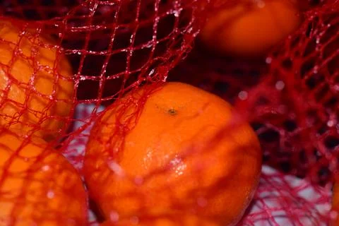 Mandarins in a red net as a close up Stock Photos