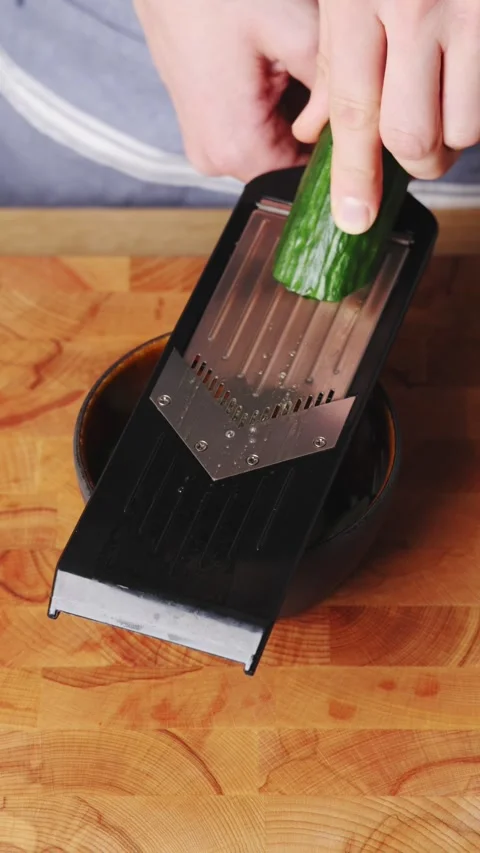 Mandoline slices cucumber thinly for cucumber salad. Stock Footage 341733823