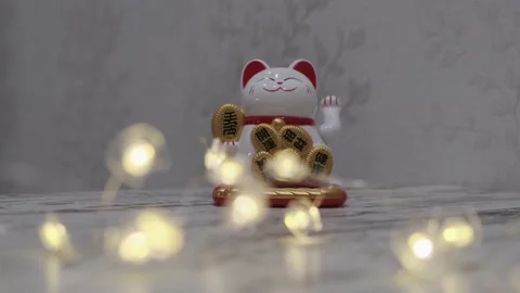 Maneki-neko ceramic cat symbolizing rich and wealth waves its left paw. Video stock 168299861