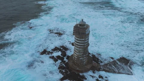 Mangiabarche Lighthouse enduring the relentless waves of the Sardinian sea Stock Footage 313291531
