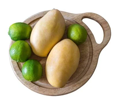 Mango and lime lie on a cutting board Stock Photos