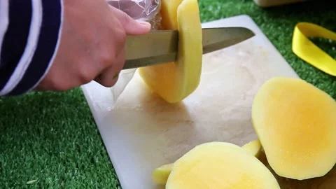 Mango being sliced using a knife on a cutting board Stock Footage 272298278