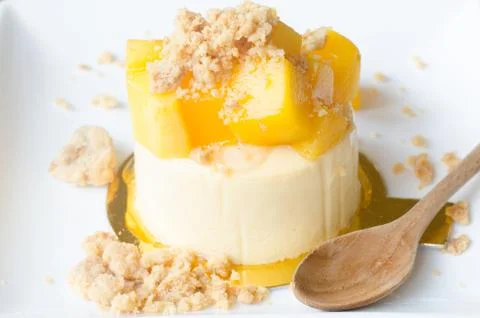 Mango cheesecake on white plate Stock Photos