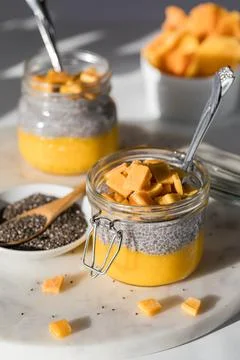 Mango chia pudding snacks in bright sunlight, ready for eating. Stock Photos