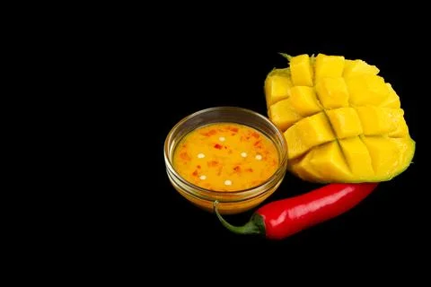 Mango chili dressing, mango and chili on black. Stock Photos