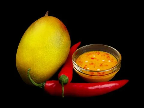 Mango chili dressing, mango and chili on black. Stock Photos