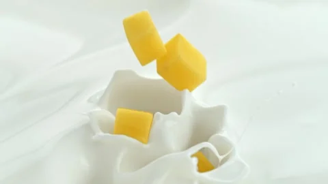 Mango Cubes Falling into Creamy Milk Making Splashes in Macro Stock Footage 274354854