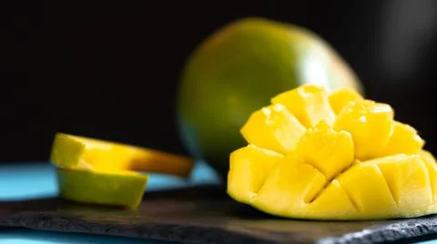 Mango cut on a dark background. Mango in home conditions not neatly cut Photos