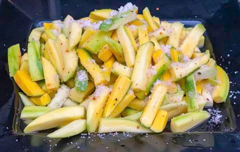 Mango cut into small pieces, sprinkle with salt, pepper and sugar. Stock Photos
