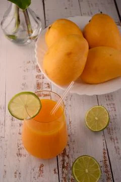 Mango drink close-up with lime slice on white vintage wooden table Stock Photos