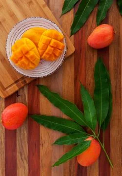 Mango fruit and mango drink on the wooden cutting board. Tropical fruit. Stock Photos