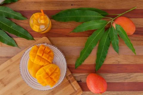 Mango fruit and mango drink on the wooden cutting board. Tropical fruit. Stock Photos
