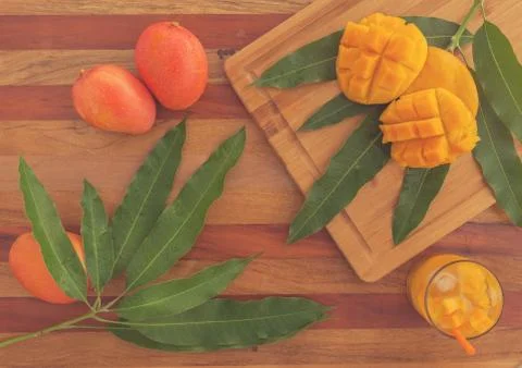 Mango fruit and mango drink on the wooden cutting board. Tropical fruit. matte Foto stock