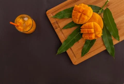 Mango fruit and mango drink on the wooden cutting board. Tropical fruit concept Stock Photos