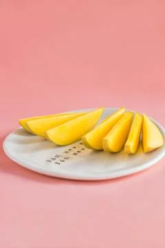 Mango fruit and mango slices on the white plate. Stock Photos