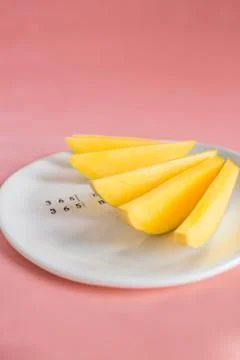 Mango fruit and mango slices on the white plate. Stock Photos