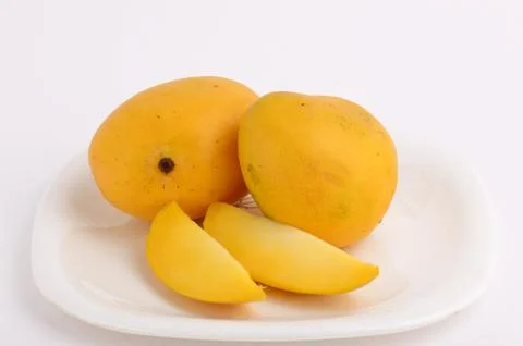 Mango fruit in basket with slice on white background Stock Photos