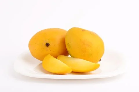 Mango fruit in basket with slice on white background Stock Photos