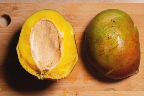 Mango fruit cut into two halves. Not a beautiful image of a cut mango at home Stock Photos