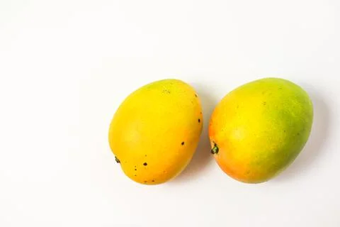 Mango fruit on cutting board isolated on white background, whole ripe yellow  Stock Photos