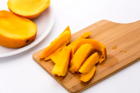 Mango fruit pulp and its peel on a cutting board Stock Photos