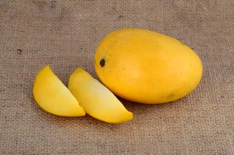 Mango fruit with slice on sack cloth background Stock Photos