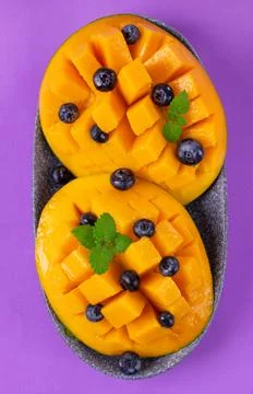 Mango halves cut into cubes and served with blueberry Foto stock