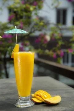 Mango juice with mango slice isolated. Glass of mango juice. Stock Photos