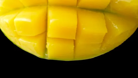 Mango juice slowly dripping from fresh fruit, black background, macro Stock Footage 328361312