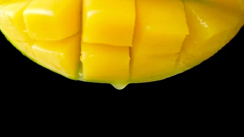Mango juice slowly dripping from fresh fruit, black background, macro Stock Footage 328848176