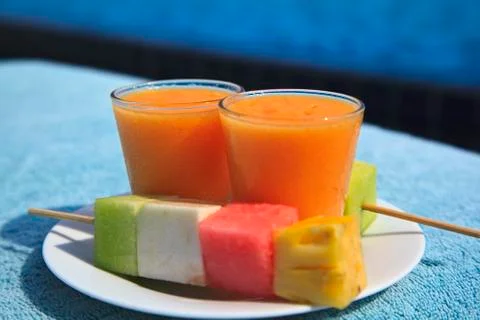 Mango juice in small cups and a scoop with fruit Stock Photos