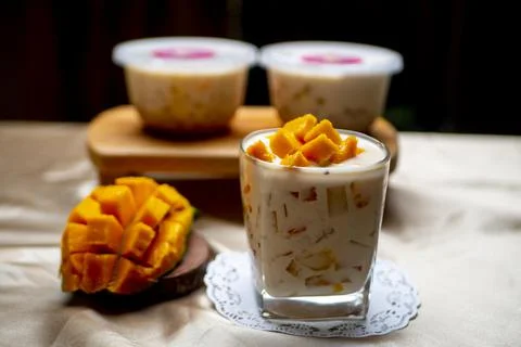 Mango Milk Cheese with a half of mango on white table with packaging for sale Stock Photos