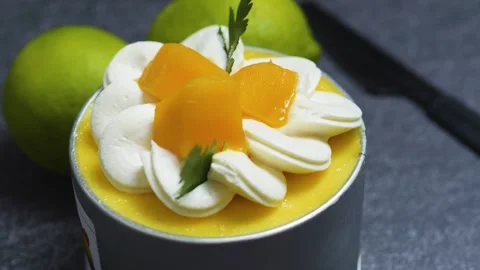 Mango mousse cake Tin Can garnished with cream rosettes, fresh mango slices, and Stock Footage 313293481