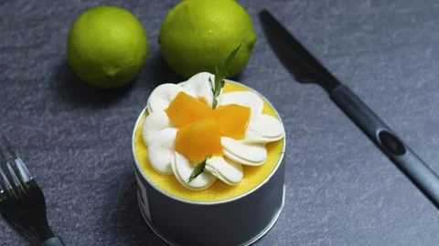 Mango mousse cake Tin Can garnished with whipped cream, fresh mango slices, mint Stock Footage 313293837