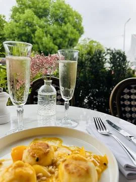 Mango mousse with sliced ripe mango on the side, two glasses of champagne on the 库存照片
