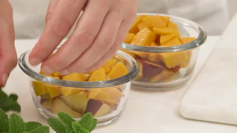 Mango, peach fruit salad close up. Sliced fruits in a glass bowls Stock Footage 132566570