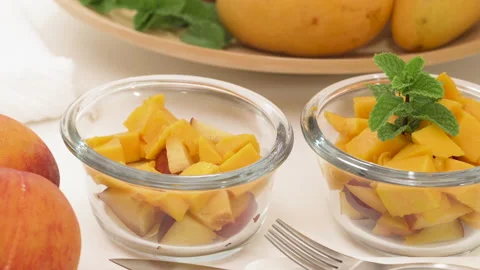 Mango, peach fruit salad close up. Sliced mangoes, peach, pine nuts, and mint  Video stock 146112478