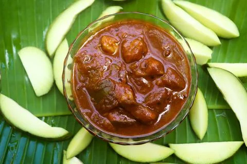 Mango pickle raw mango sliced with chilly salt placed on banana leaves Stock Photos