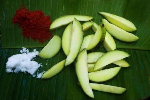 Mango pickle raw mango sliced with chilly salt and placed on banana leaves Stock Photos