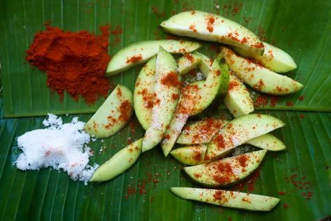 Mango pickle raw mango sliced with chilly salt and mustard dal placed on banana Stock Photos