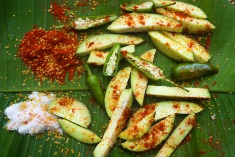 Mango pickle raw mango sliced with chilly salt and placed on banana leaves Stock Photos