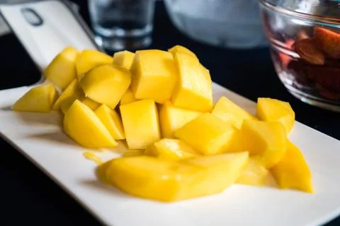 Mango pieces on white dish Stock Photos