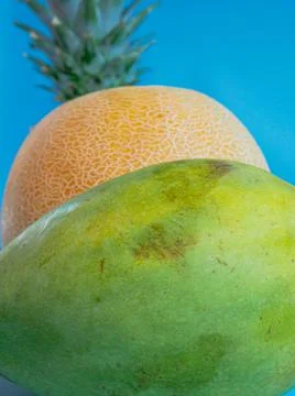 Mango, pineapple and melon on a blue background Stock Photos